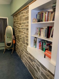 My favorite part of the house is the wall with the exposed stone and bookshelf