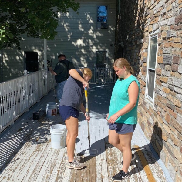 Two girls helping Michael re-paint the porch