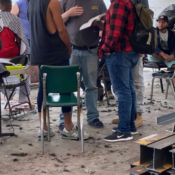 Justin witnessing to a man at the migrant center as Alfredo translates
